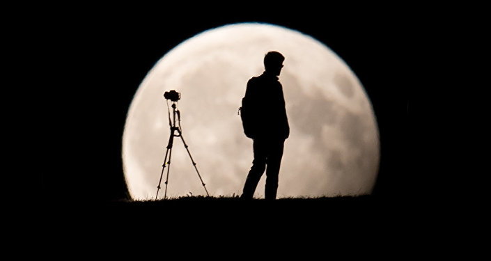 Фотограф снимает частичное лунное затмение в Мюнхене, Германия
